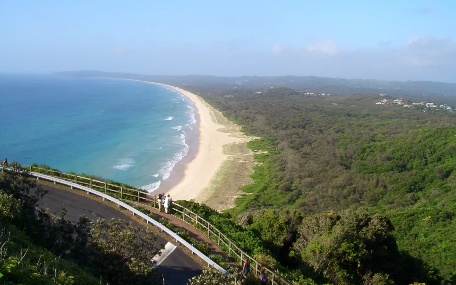 A nature trail in Arakwal National Park, Byron Bay, lush green coastal forest and the quiet, empty white sand of Tallow Beach