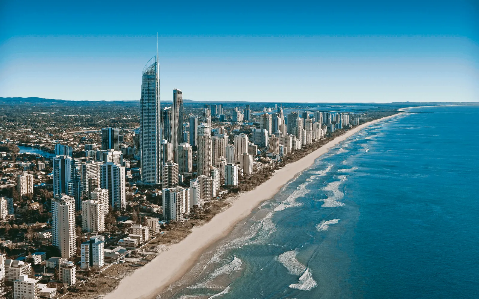 A humpback whale breaching out of the Pacific Ocean off the Gold Coast, its tail thrown skyward before diving back down