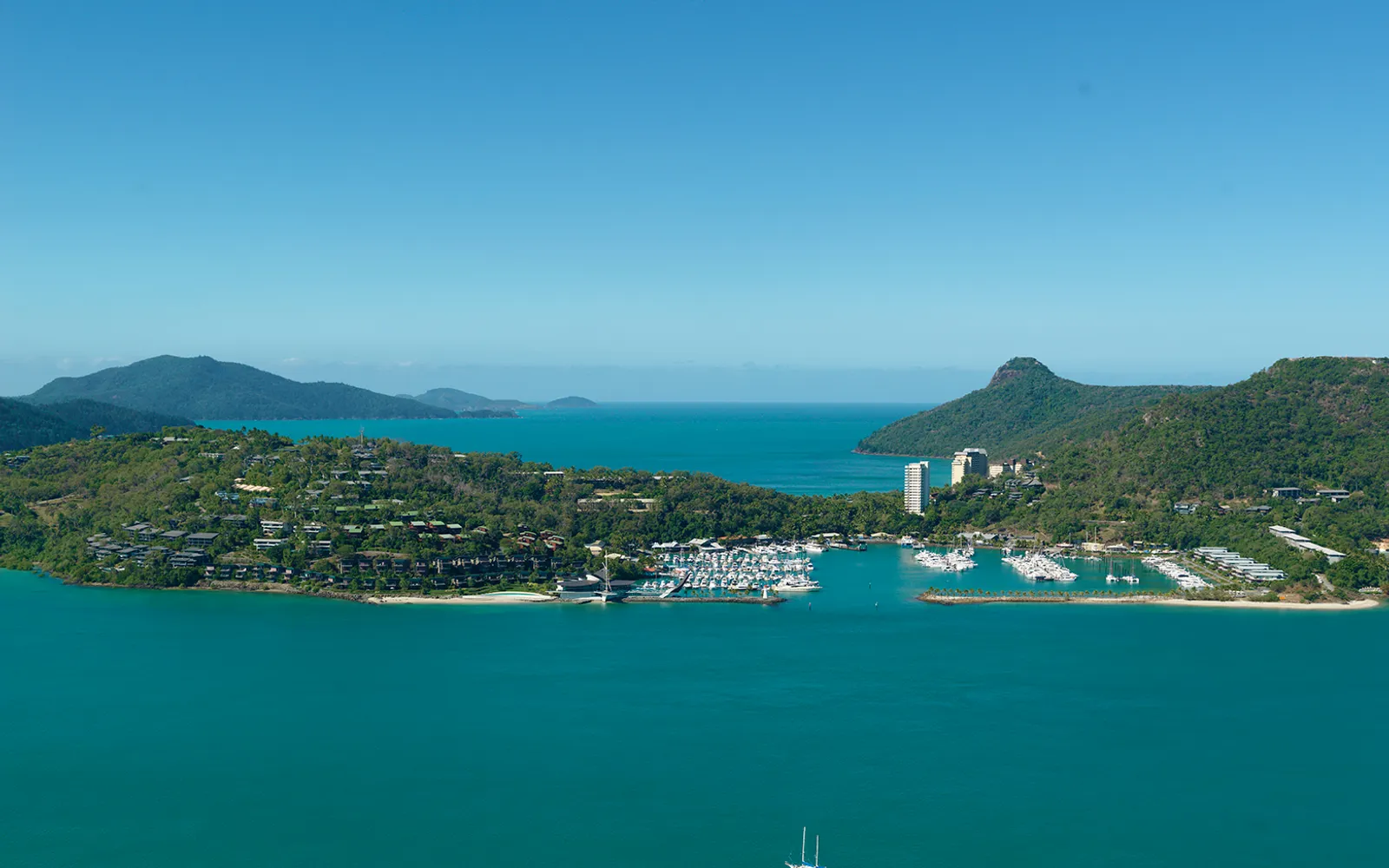 Sunset at One Tree Hill on Hamilton Island, golden-orange light pouring over the sea and the small surrounding islands of the Whitsundays