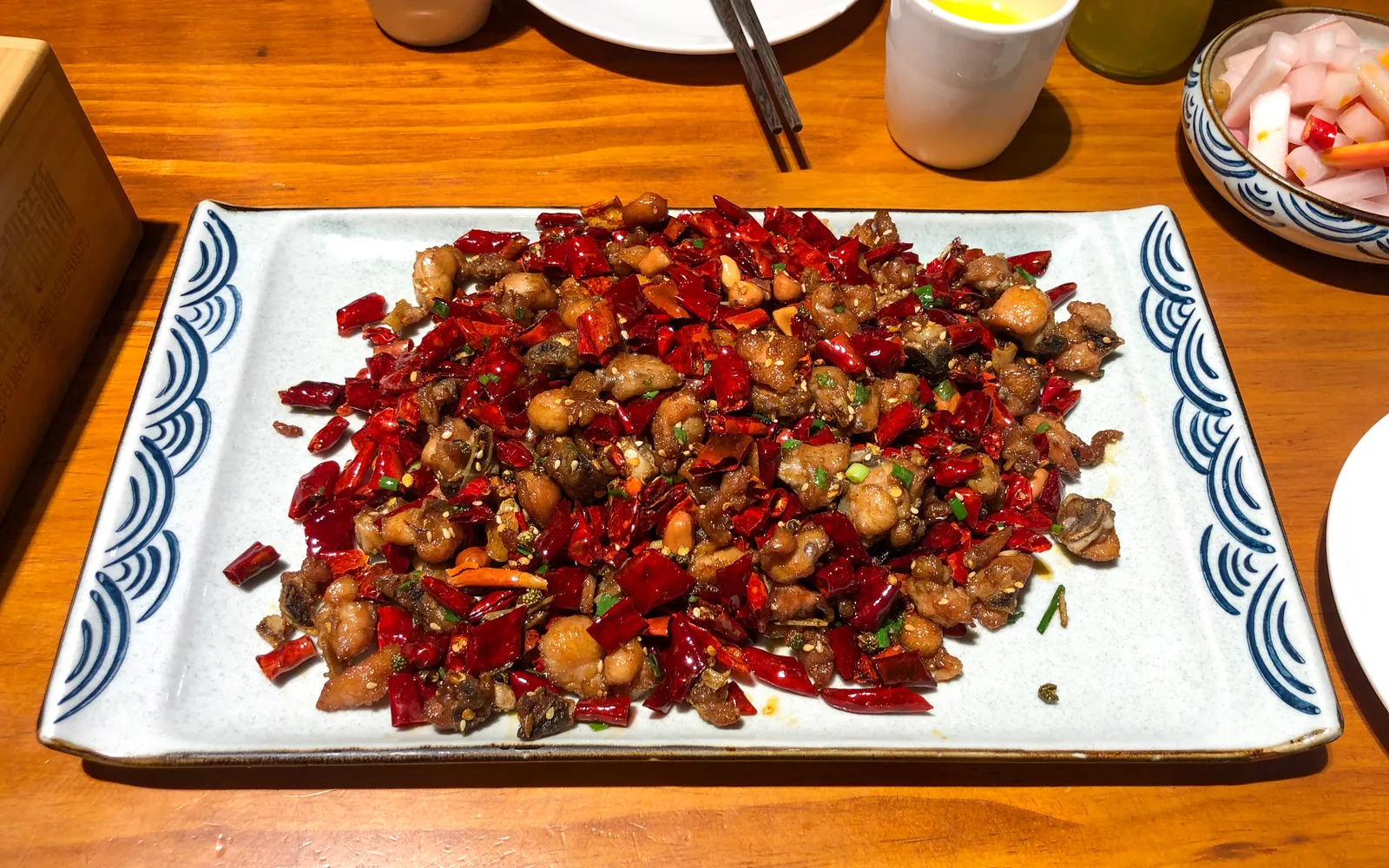 A plate of Chongqing laziji fried chicken hidden under a huge pile of dried red chillies