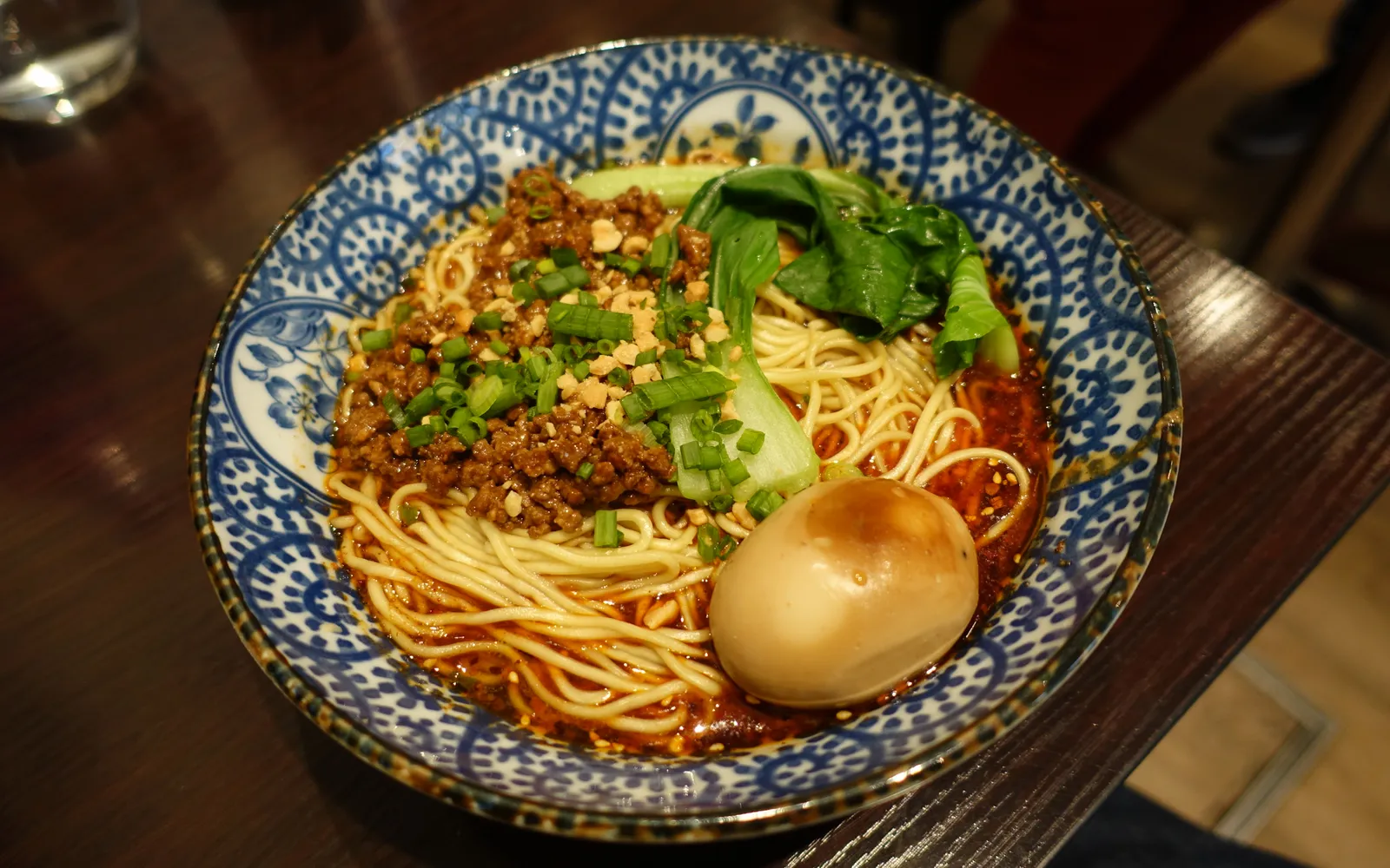 Chongqing xiaomian noodles dressed in fresh red chilli oil, topped with green spring onion