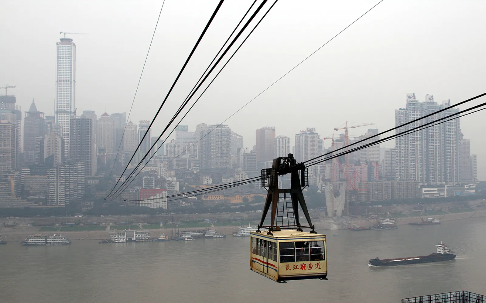 A cable car crossing the Yangtze River with Chongqing's high-rises in the background