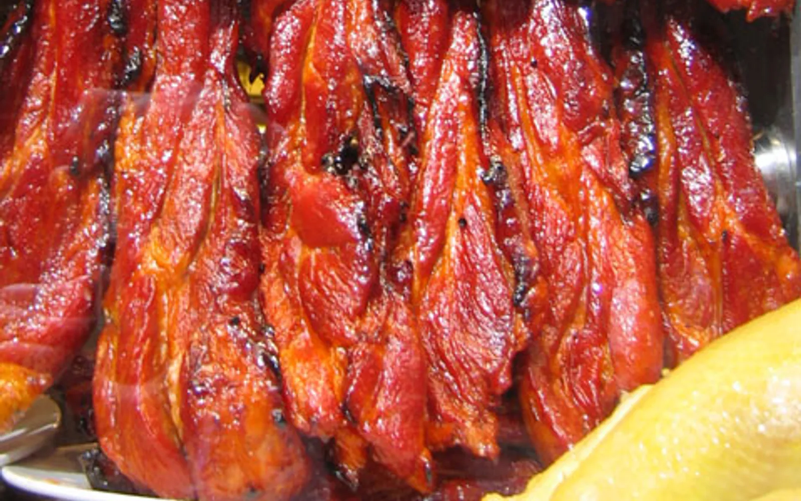 Glossy red barbecue pork glazed with honey, sliced and ready to serve on a Cantonese plate