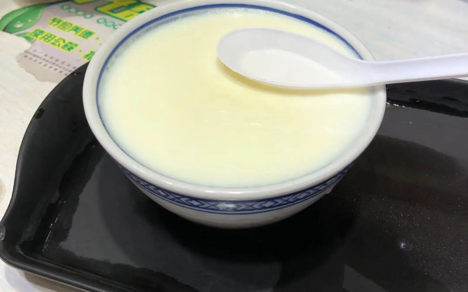 A white ceramic cup of double skin milk pudding with a smooth, silky, creamy-white surface, an original Cantonese dessert