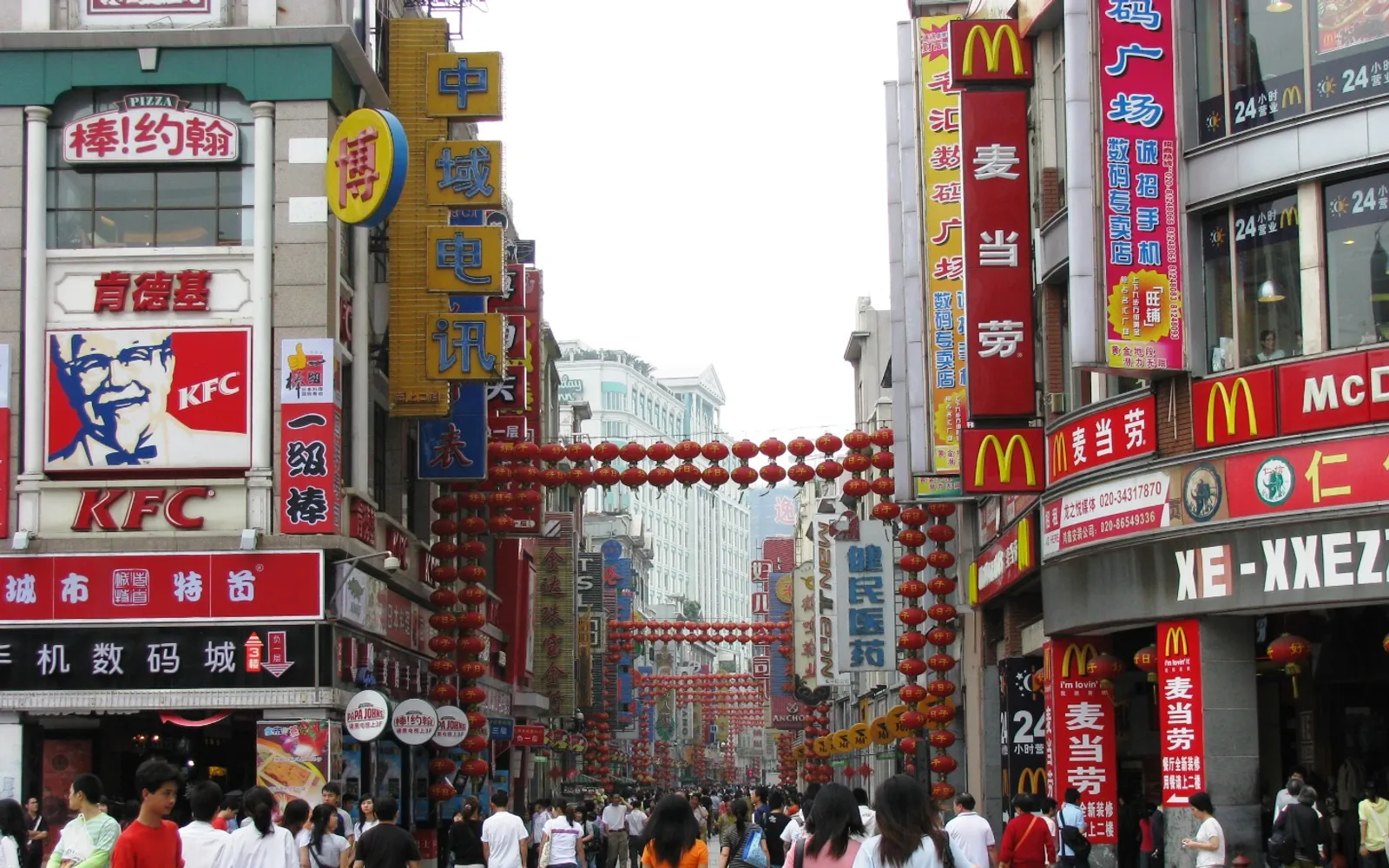 Shangxiajiu Pedestrian Street at night, full of shops, food stalls and visitors among the Tong Lau-style buildings