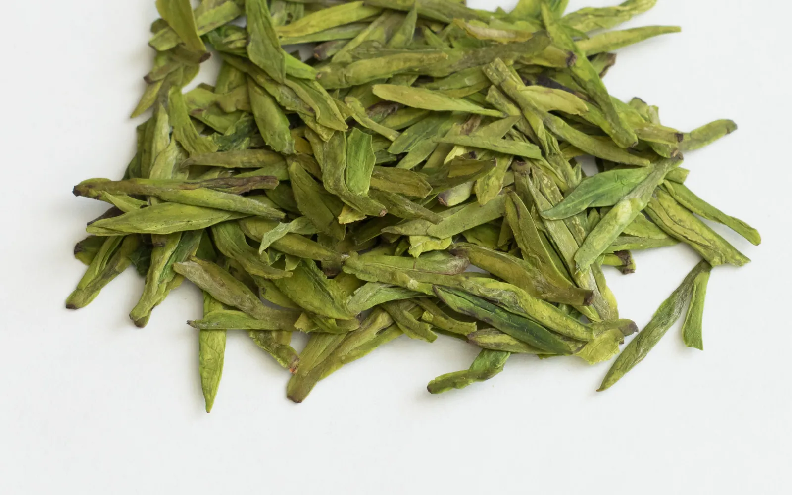 White shrimp stir-fried with pale green Longjing tea leaves, plated on white porcelain