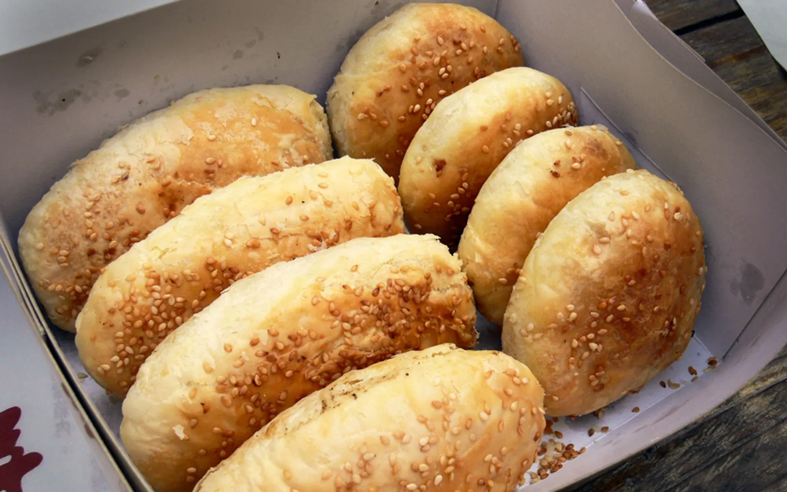 A baked flatbread topped with black and white sesame from a traditional brick oven