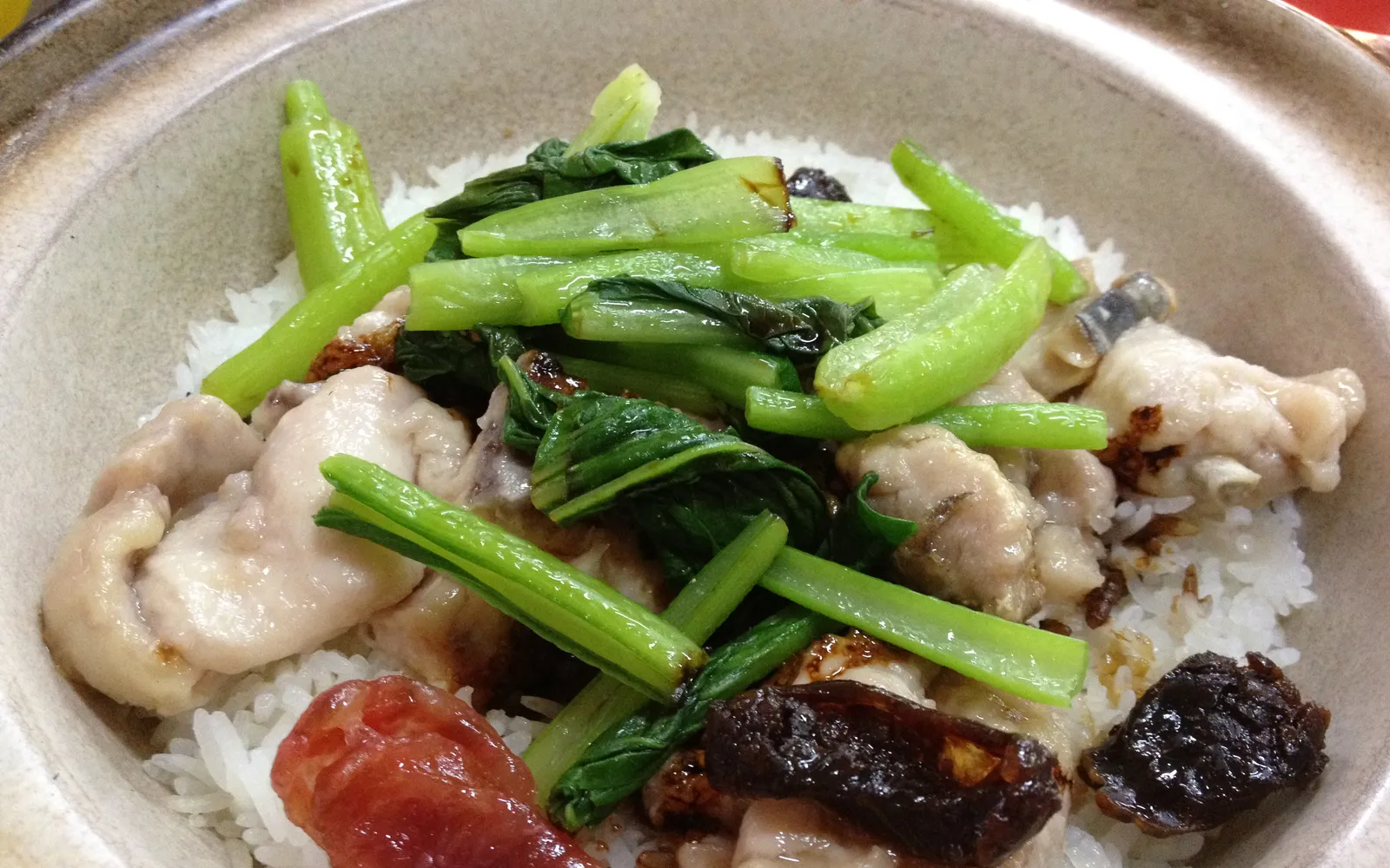 Cantonese claypot rice with lap cheong sausage, garlic and soy sauce, served in a dark clay pot