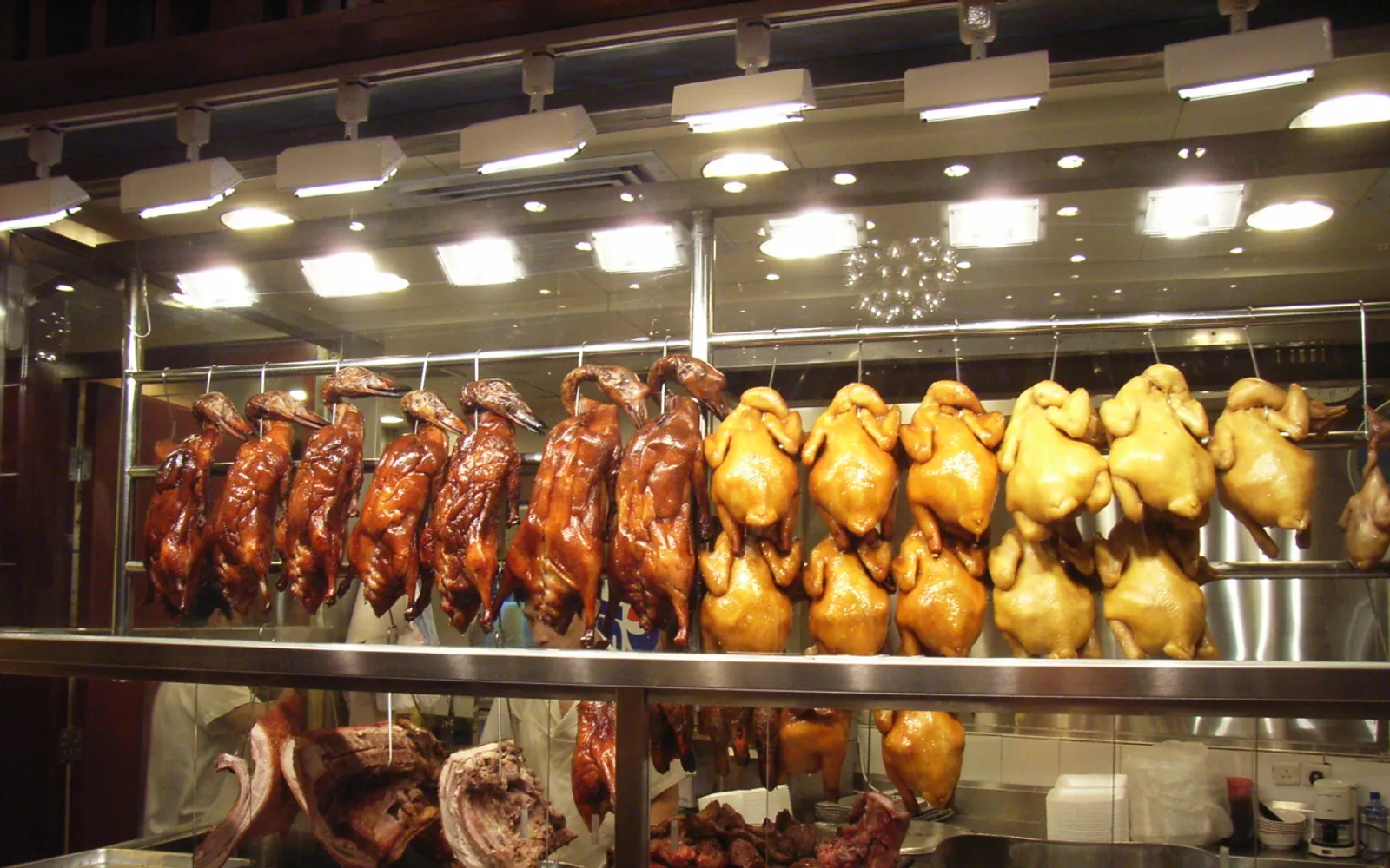 Glossy red-brown char siu roast pork hanging in the window of a Cantonese siu mei shop in Shenzhen