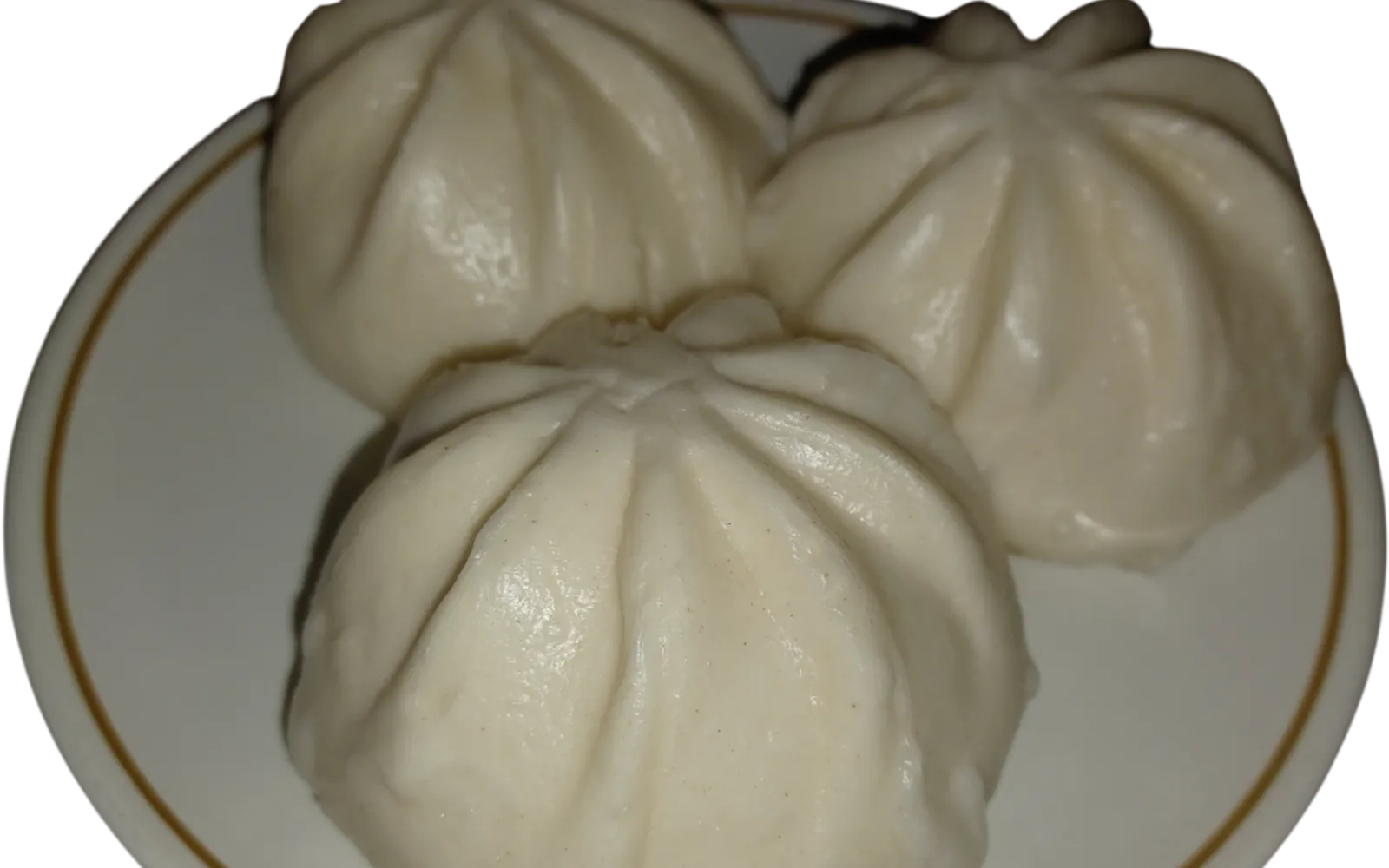 Goubuli lean-pork steamed buns in a bamboo steamer, thin skins folded into 18 neat pleats arranged on white steaming cloth