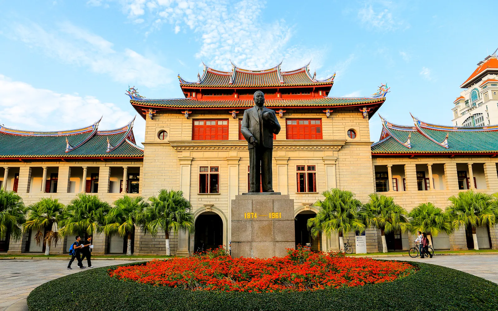 Shapowei Art Village in Xiamen — old houses painted in bright colours with large murals, young people sitting with coffee in front of small shops along the old harbour