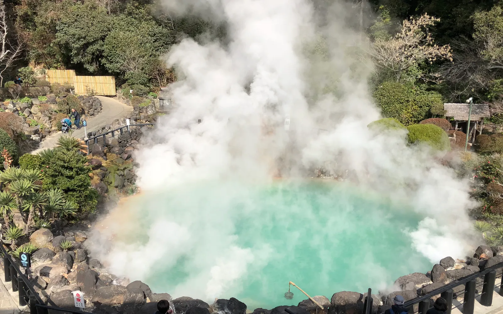 Chinoike Jigoku's deep red hot spring, steam rising over the surface