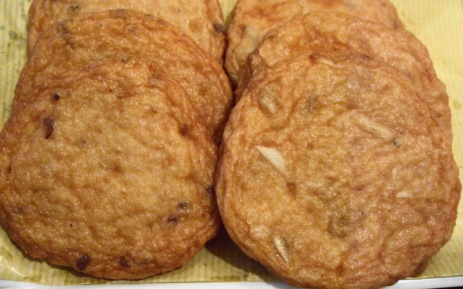 Golden Satsuma-age fish cakes in various shapes arranged on a bamboo basket