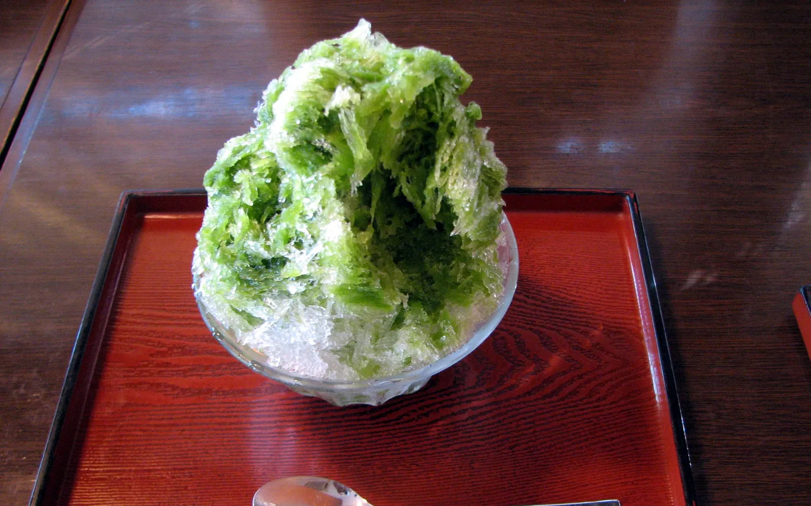 Large Shirokuma shaved ice mounded high with sweet condensed milk and colourful fresh fruit arranged as a polar bear face