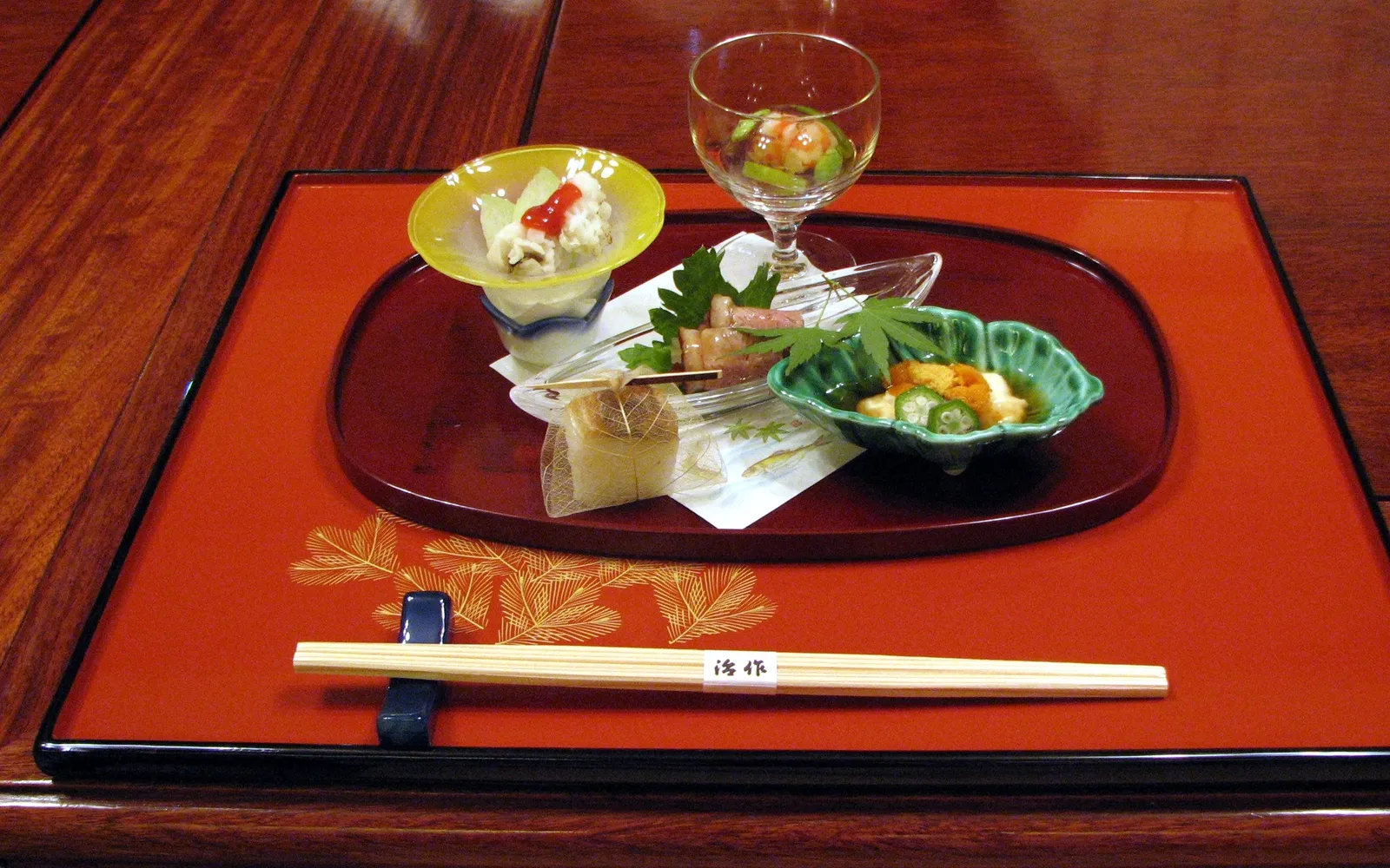 A kaiseki set in Kaga style, arranged on lacquered wooden trays with Kaga vegetables and seasonal fish