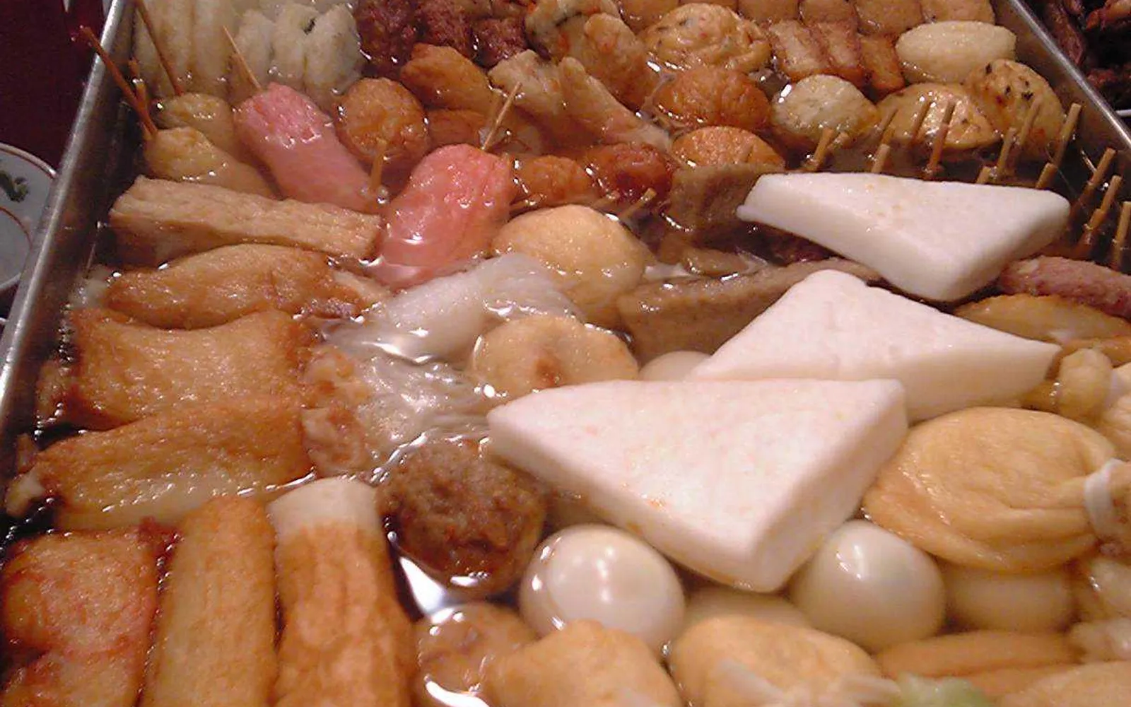 A pot of pale-amber Kanazawa oden simmering with snow crab shell, fried tofu, and kuruma-fu in the broth