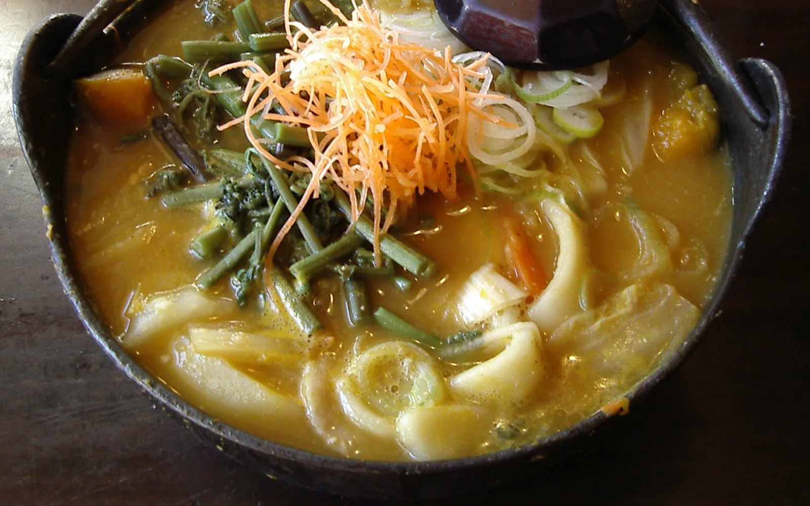 Clay pot of hoto flat noodles in rich miso broth with pumpkin and vegetables