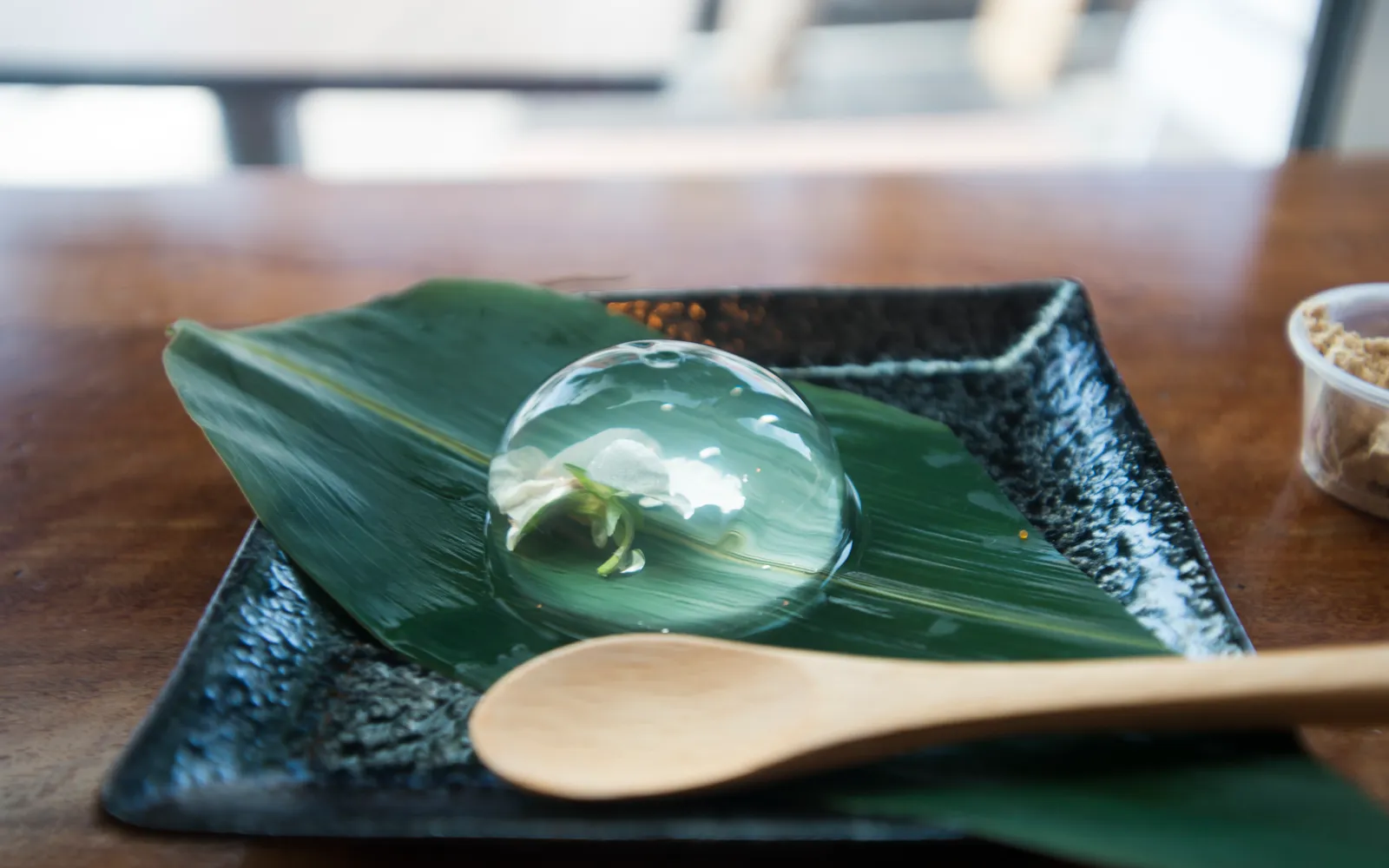 Transparent Mizu Shingen Mochi resembling a large water droplet sitting in a dish