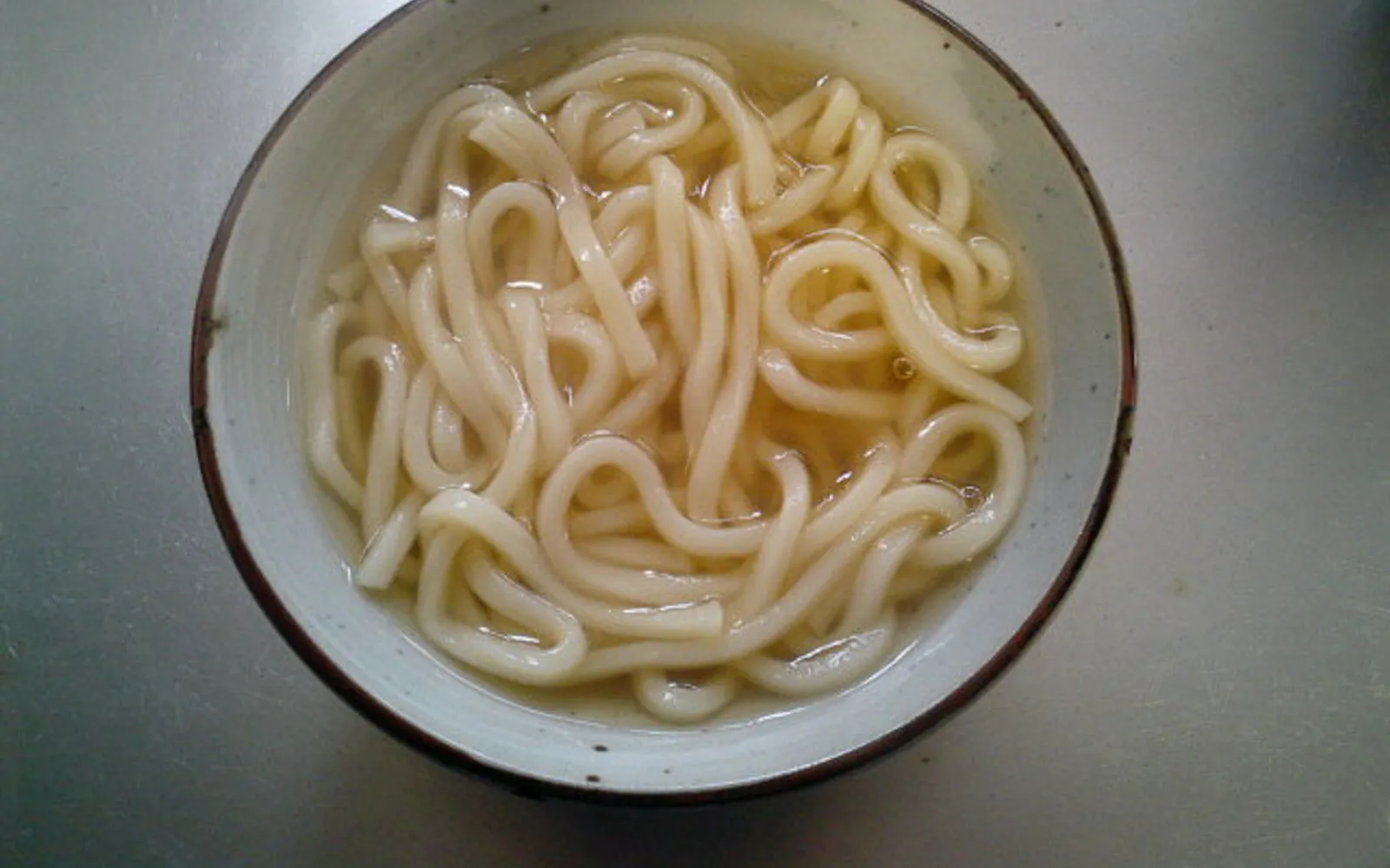 Bowl of thick, very firm udon noodles in miso-soy broth