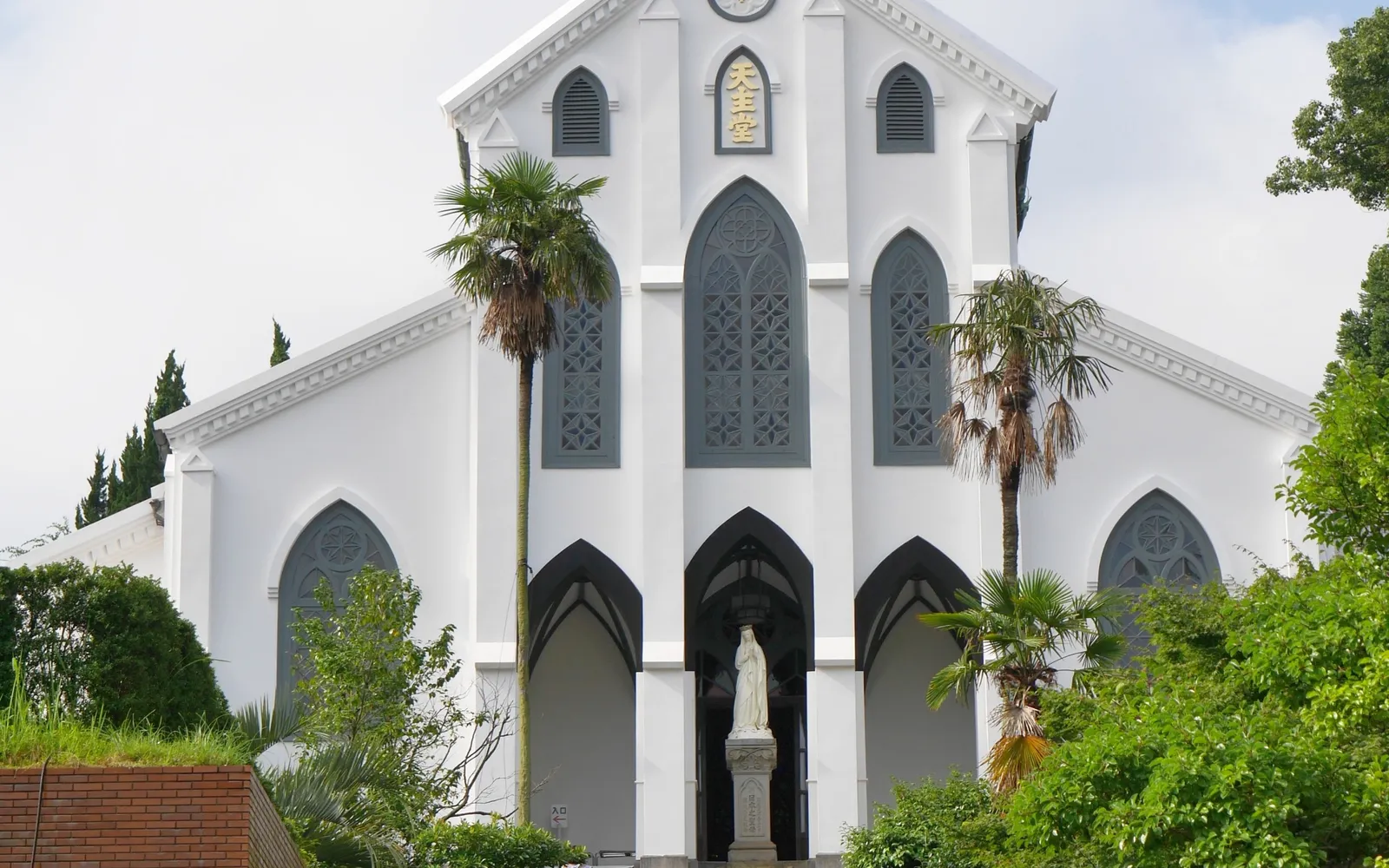 Oura Cathedral's white Gothic facade rising above the wooded hillside of Nagasaki