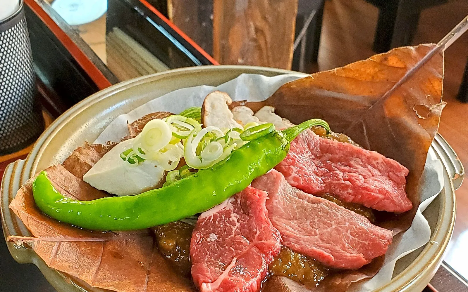 Miso paste and Hida wagyu beef grilling on a large ho-no-ki magnolia leaf over a tabletop charcoal brazier