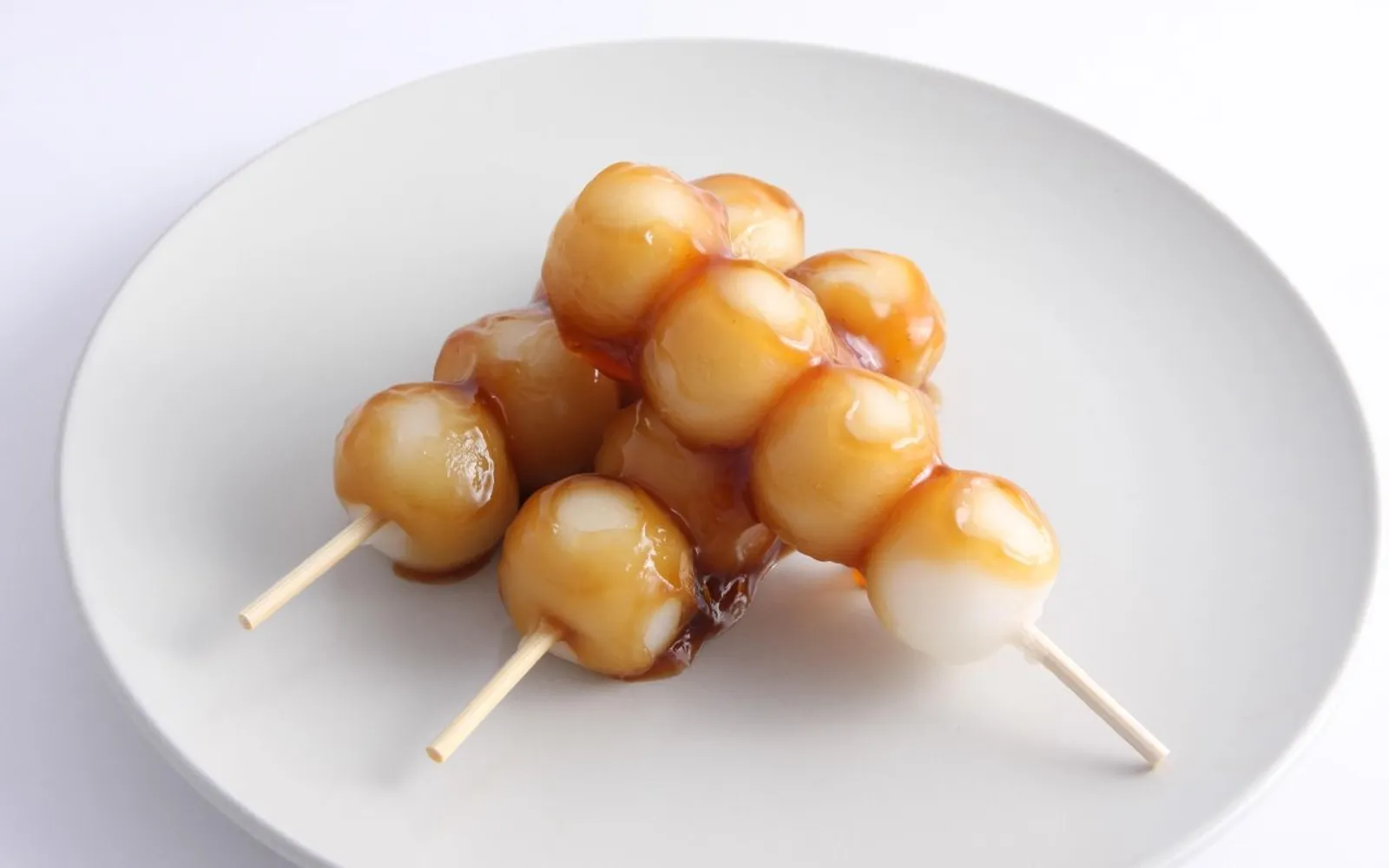 Takayama mitarashi dango on skewers, brushed with soy sauce and charcoal-toasted to a deep brown