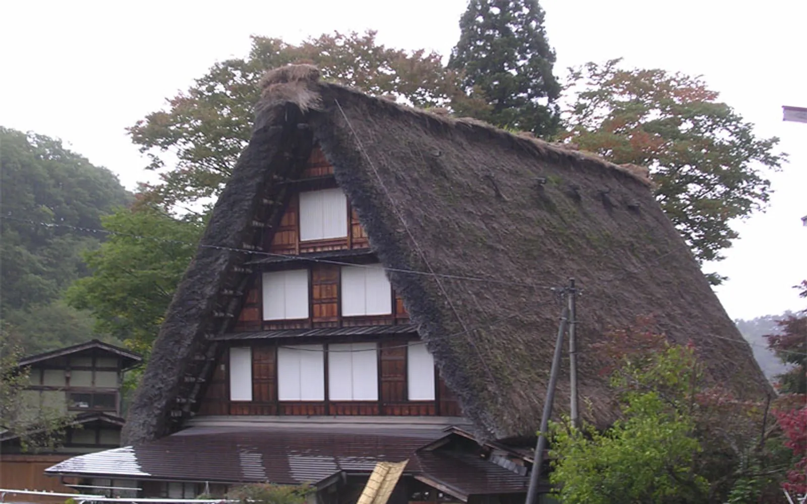 Multiple thatched-roof farmhouses of Hida no Sato open-air museum surrounded by nature