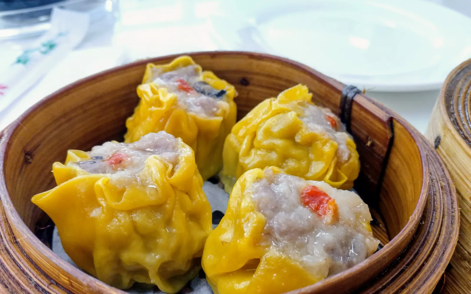 Golden-yellow steamed shumai dumplings from Kiyoken arranged neatly in an elegant bento box