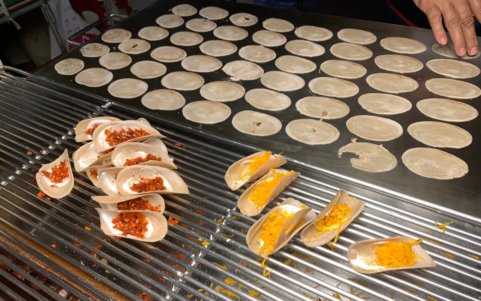 Crispy folded Khanom Bueang shaped like a taco, topped with white meringue and golden egg-yolk threads