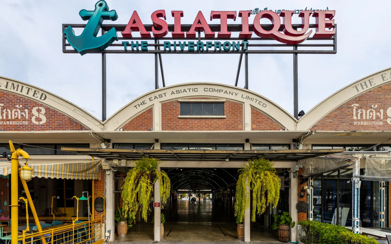 Asiatique The Riverfront at night, a Ferris wheel glowing in coloured lights above the outdoor market on the Chao Phraya