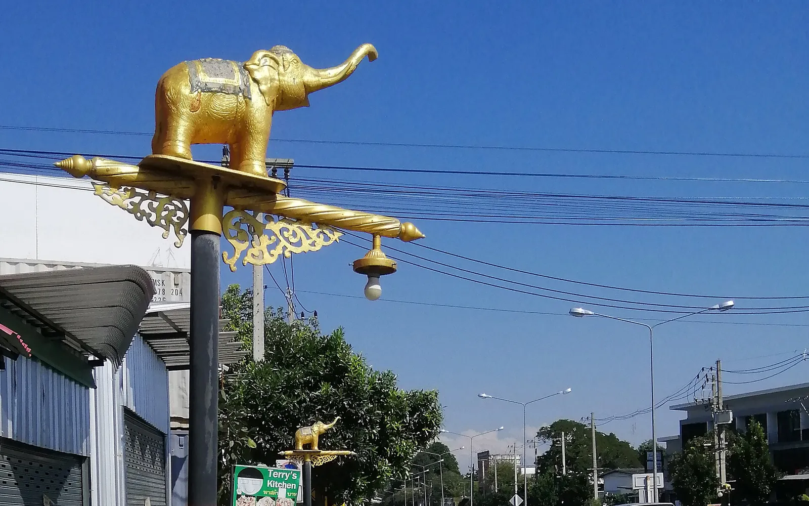 Nimmanhaemin Road in Chiang Mai lit up at night, with colourful cafes lining the footpath