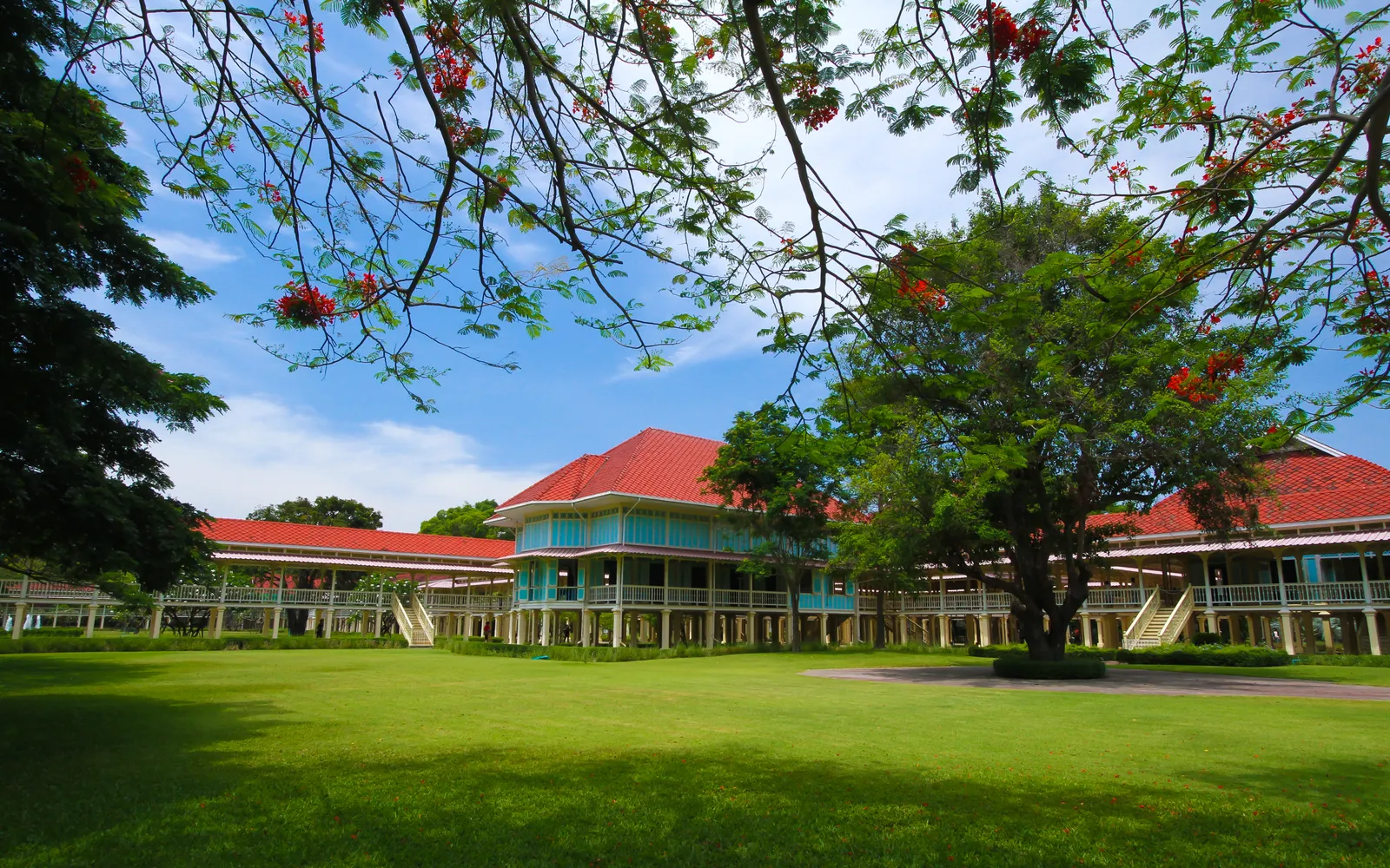 Mrigadayavan Palace — a long-verandahed golden teak building raised on concrete columns above the beach, calm and quiet in the afternoon light