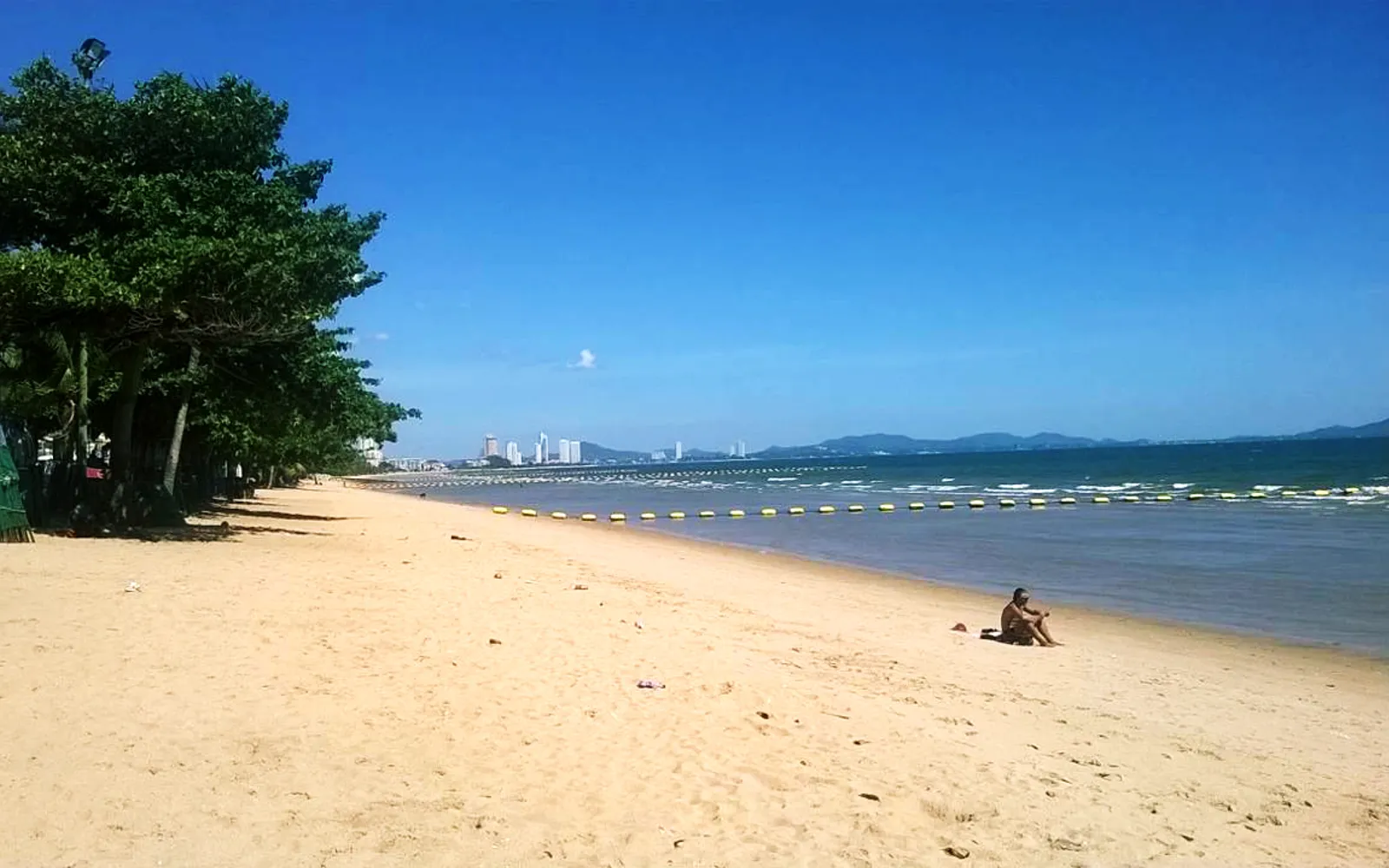 Jomtien Beach near Pattaya — more than 6 kilometres of white sand, quieter than the main Pattaya beach, with sun loungers and parasols along the full length